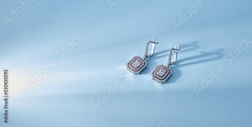 Diamond jewelry. Diamond earrings on color background