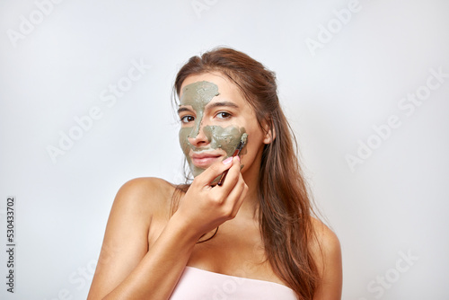 The girl uses blue clay for face care. Beauty concept, skin care cosmetics, facelift. Beauty salon. Wrinkle removal.