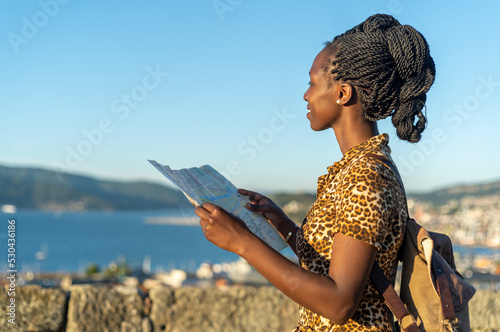 Young tourist woman viewing a map while visiting a European city
