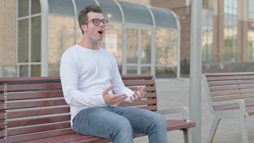 Angry Young Man Feeling Frustrated while Sitting Outdoor on Bench