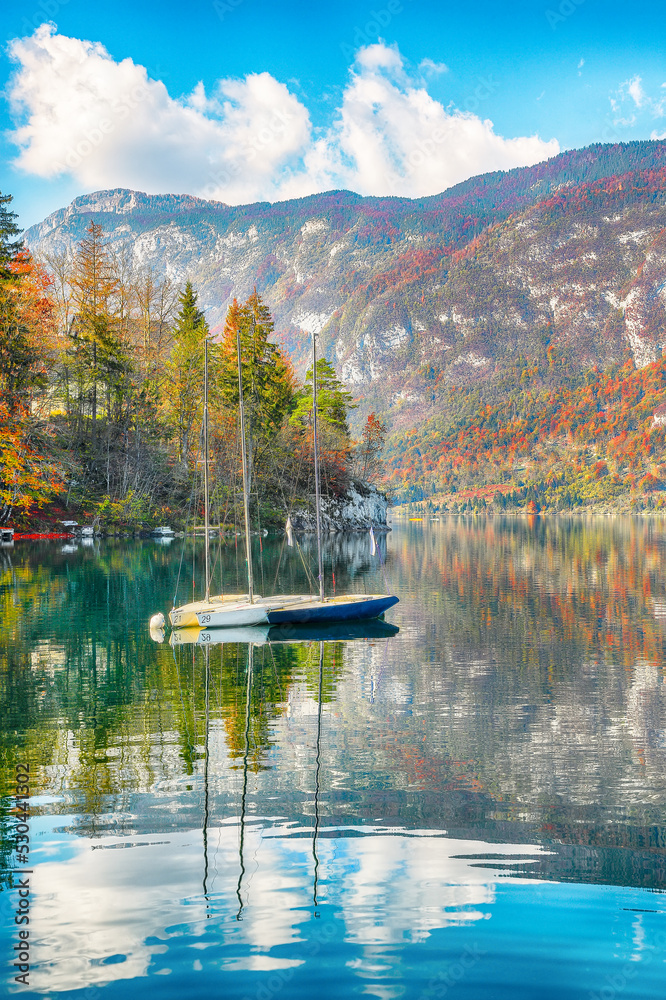 Amazing  view  of  Bohinj Lake with boats during autumn .