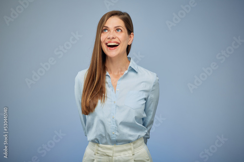 Smiling business woman holding hands back and looking up. isolated portrait on blue