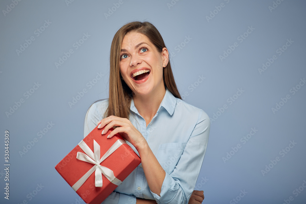 Happy woman holding gift box looking up. Isolated female portrait. Happy woman holding gift box looking up. Isolated female portrait.