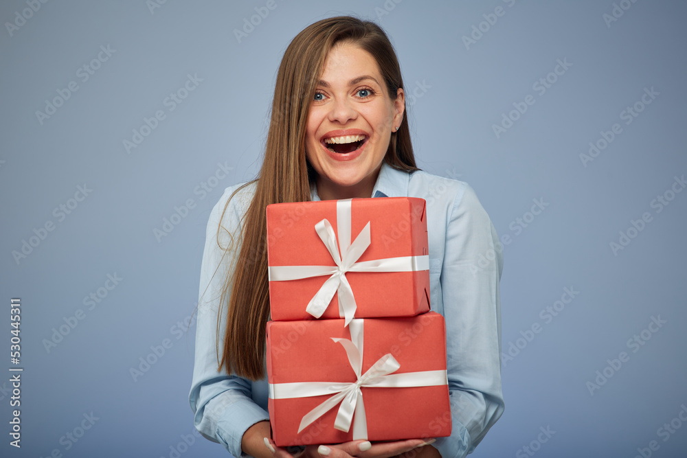 Portrait happy smiling girl with present box isolated over blue background. Portrait happy smiling girl with present box isolated over blue background.