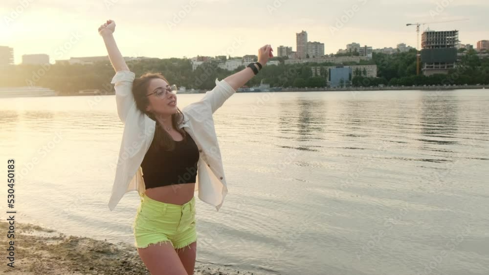 Beautiful girl in green shorts and a white shirt walks along the shore near the river. Stretching and enjoying the sunset
Beautiful girl in green shorts and a white shirt walks along the shore near the river. Stretching and enjoying the sunset