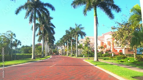 Pov car driving on Barefoot beach boulevard road in Bonita Springs, Florida in residential community with single family houses, wealthy real estate property residences photo