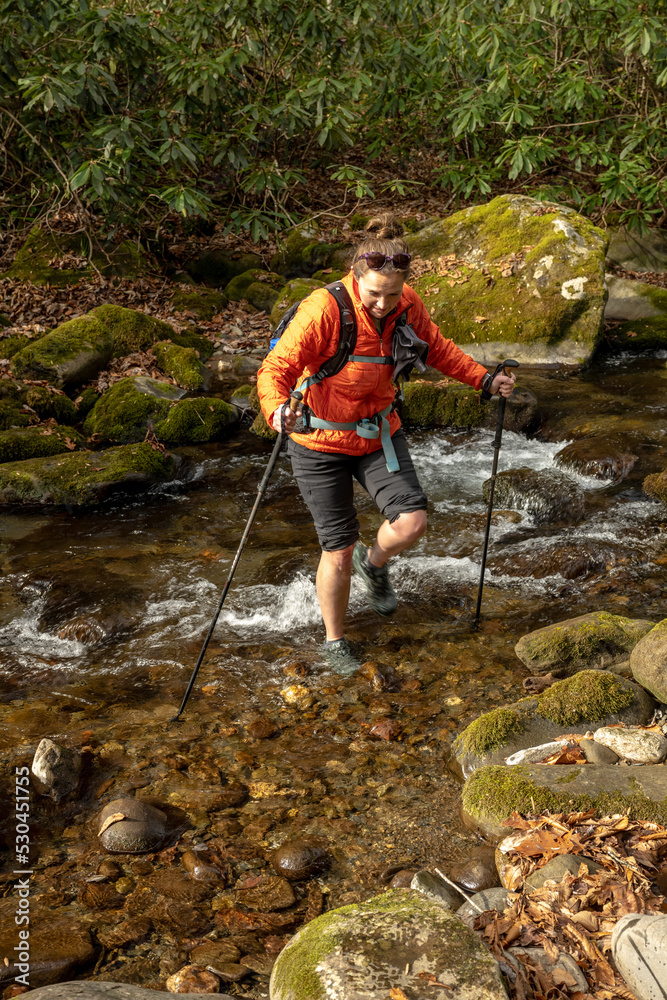 Female Hiker Emerges From Creek Ford In the Fall