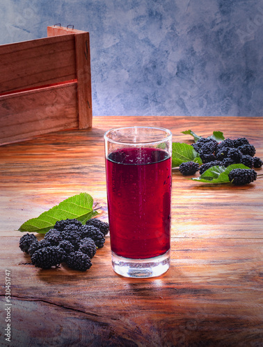 Suco de amora, mesa de madeira, frutas e folhas photo