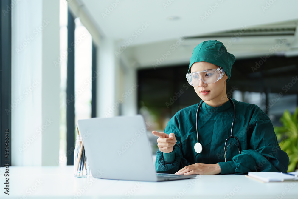 Asian doctor using a computer to look at patient information. Asian doctor using a computer to look at patient information.
