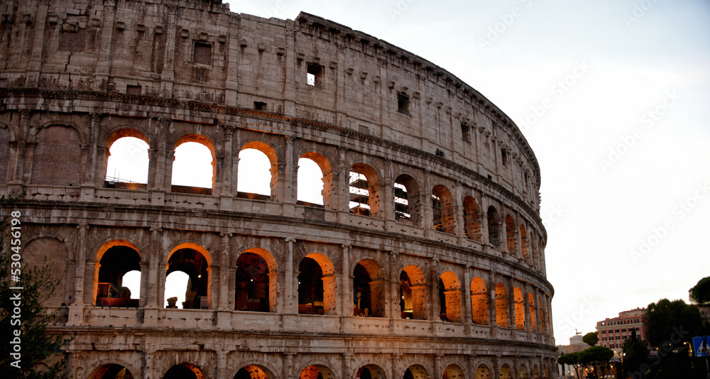 A view of the roman colosseum during sunset in the summer.