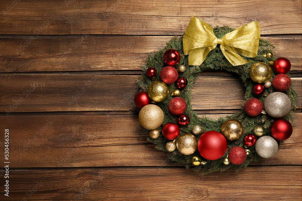 Beautiful Christmas wreath with festive decor on wooden background. Space for text