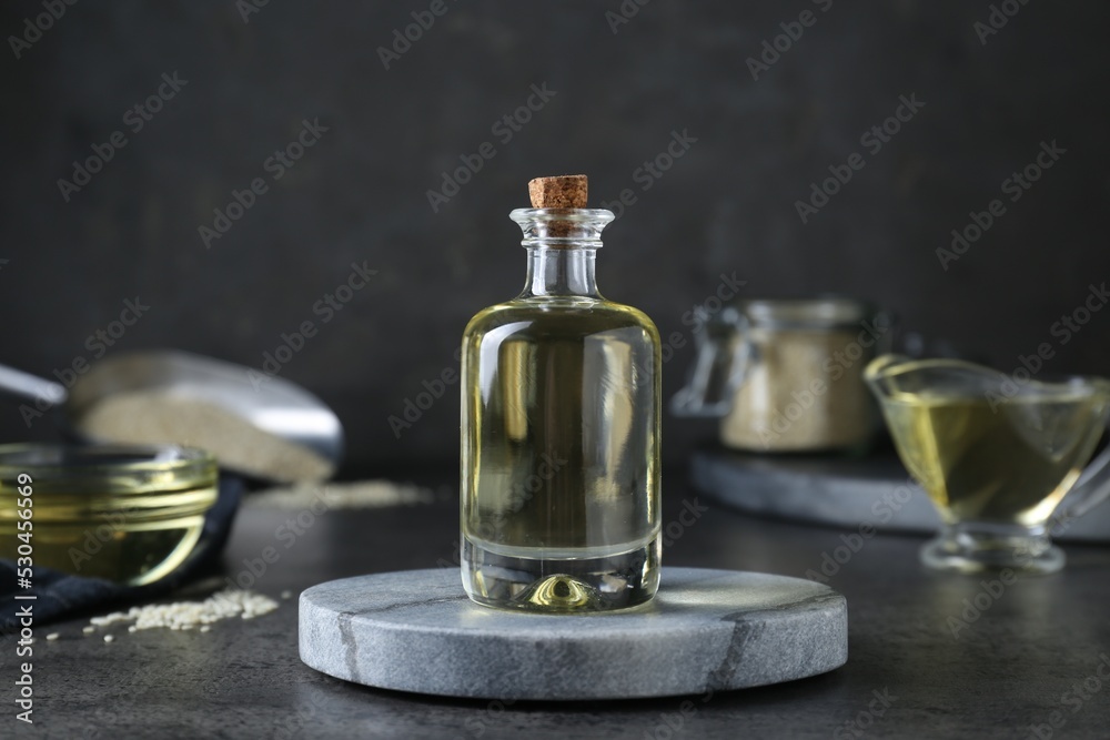 Sesame oil in glass bottle on dark grey table