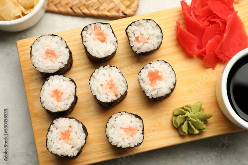 Tasty sushi rolls served on grey table, flat lay
