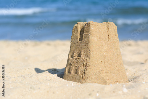 Beautiful sand castle on beach near sea, space for text