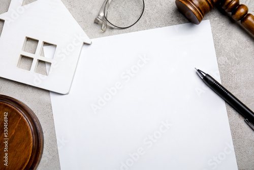 Last will and testament near house figure, glasses and gavel on light grey table, flat lay
