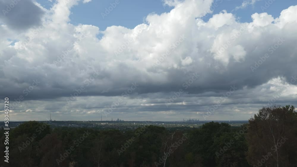 An overview of a city suburbs under fluffy clouds from a hill top. An overview of a city suburbs under fluffy clouds from a hill top.