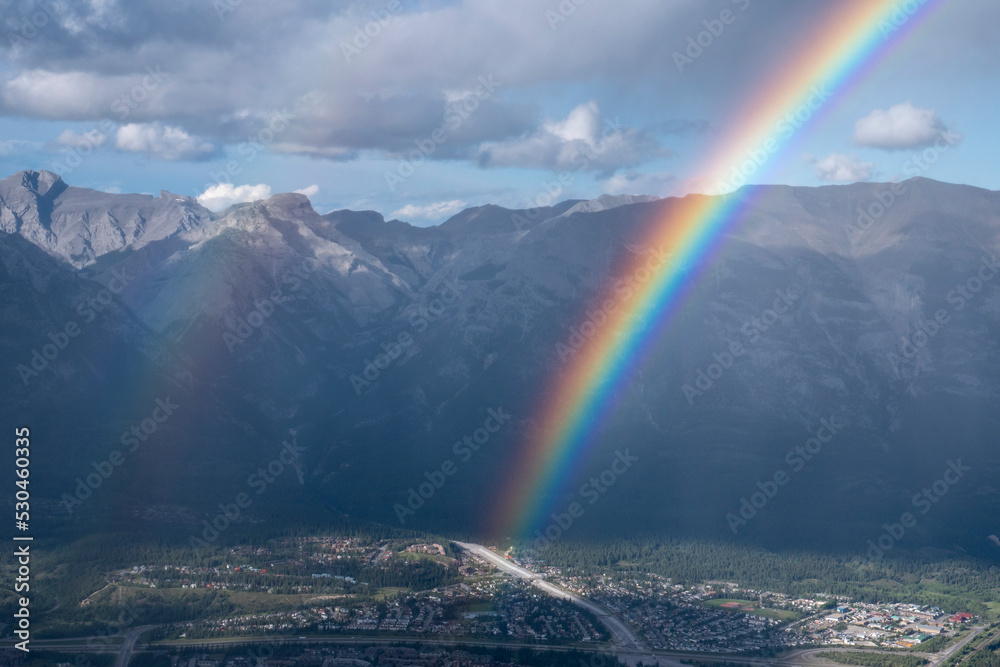 Rainbow in front of  Canmore, Alberta, Canada from a mountain peak