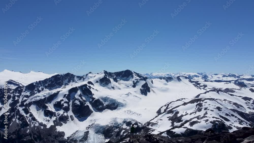 Epic Aerial Drone Shot of Hiker Looking Over Huge Snow Capped Mountain Landscape in Pacific Ranges Canada BC 4K Epic Aerial Drone Shot of Hiker Looking Over Huge Snow Capped Mountain Landscape in Pacific Ranges Canada BC 4K