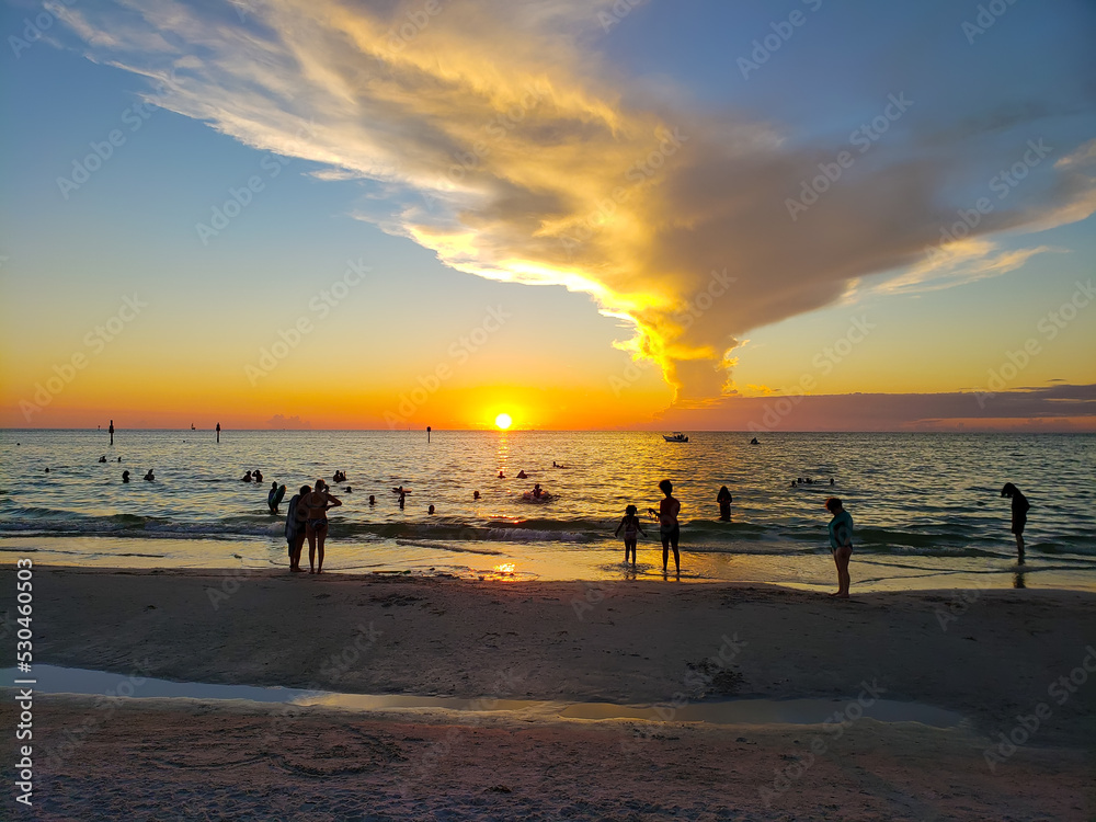 beautiful sunset on the beach in the gulf of mexico. People admire the phenomenon of nature.