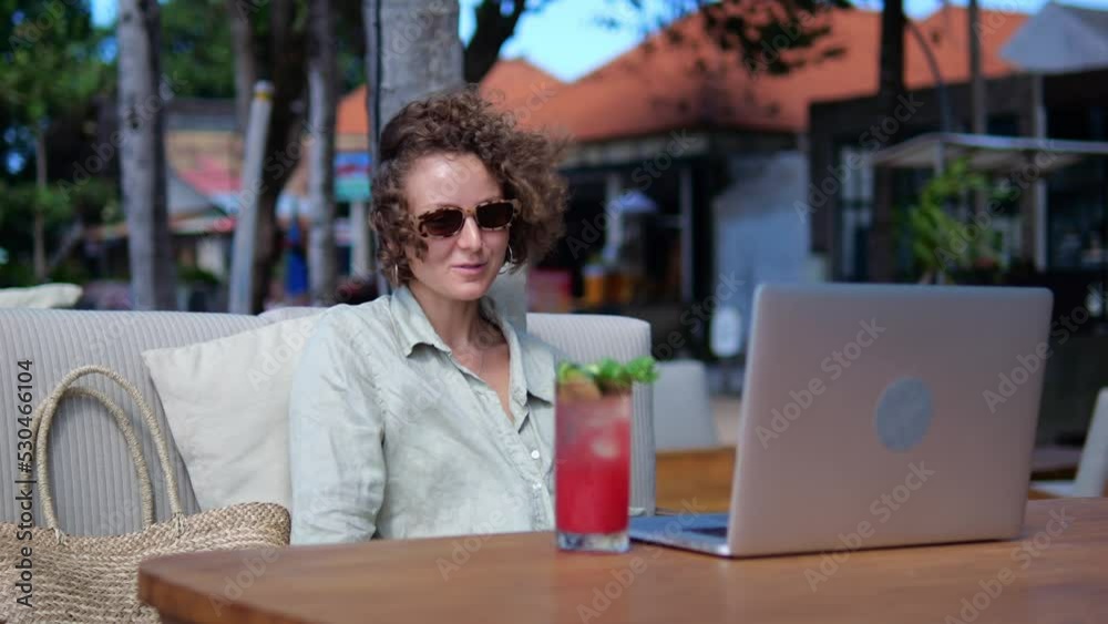 A woman on vacation communicates via video link over the Internet using a laptop. A curly-haired woman blogger tells her subscribers how to work remotely and live in warm countries. Infocoaching A woman on vacation communicates via video link over the Internet using a laptop. A curly-haired woman blogger tells her subscribers how to work remotely and live in warm countries. Infocoaching