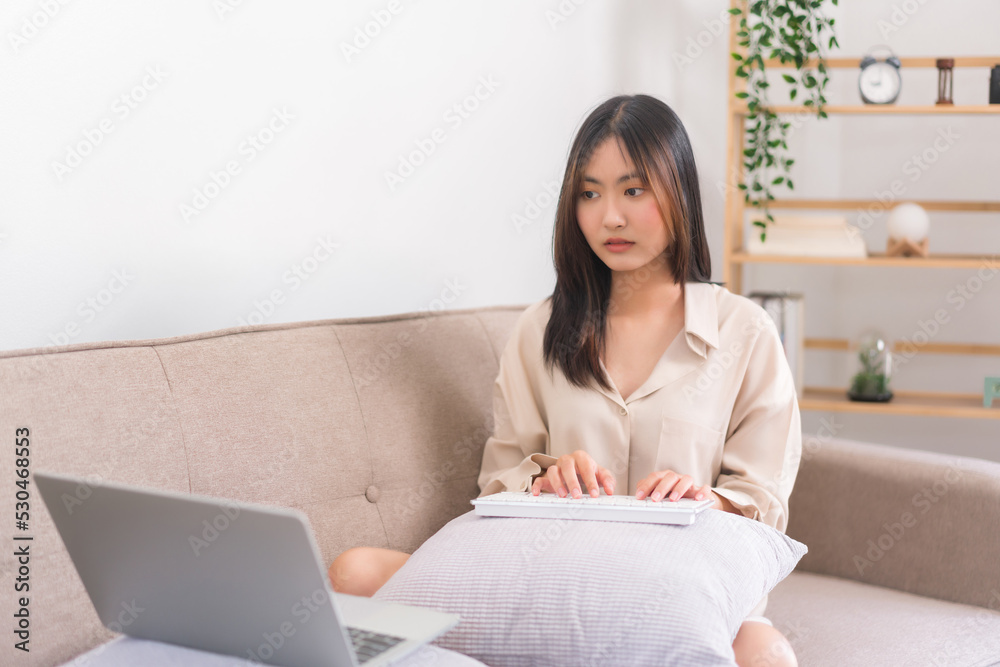 Relaxation lifestyle concept, Asian woman use keyboard to typing on laptop while working at home Relaxation lifestyle concept, Asian woman use keyboard to typing on laptop while working at home