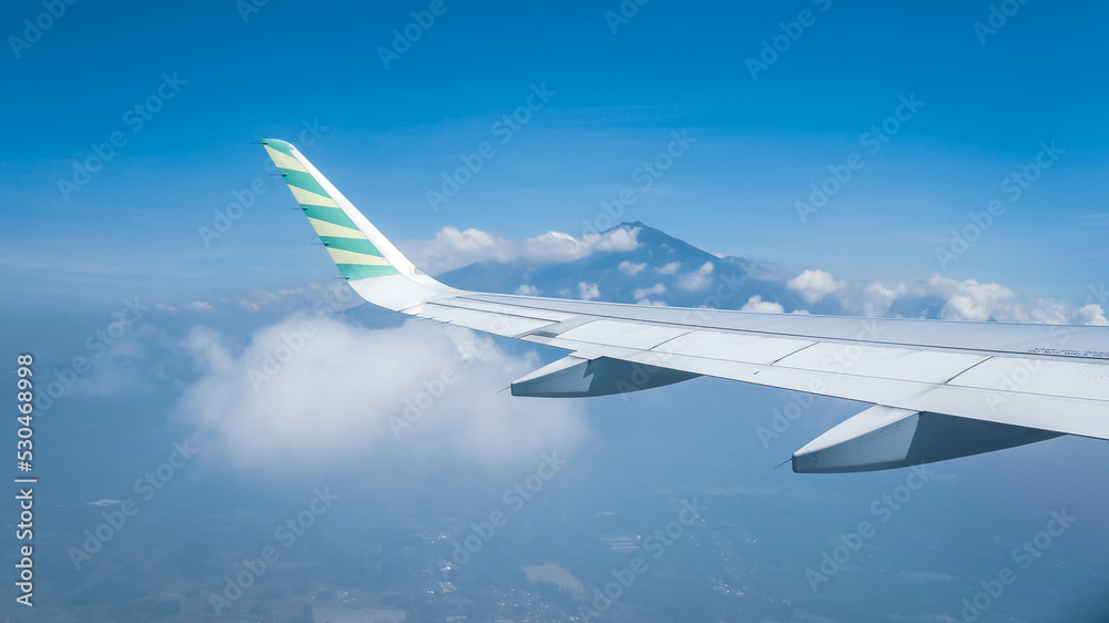 airplane wings over the air against the background of blue sky and mountains airplane wings over the air against the background of blue sky and mountains
