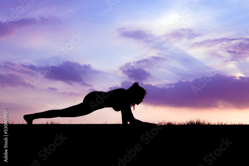 Fototapet The slender girl is doing a yoga warm-up exercise outdoors