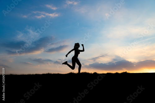 The silhouette of the back of a girl jumping and running in the morning glow © Mulin