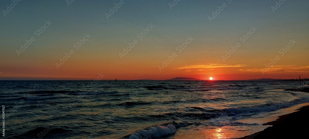Beautiful Golden, Orange Sunset over the Blue Water Sea in Tarquinia, Italy Beautiful Golden, Orange Sunset over the Blue Water Sea in Tarquinia, Italy
