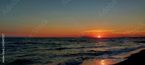 Tableau sur toile Beautiful Golden, Orange Sunset over the Blue Water Sea in Tarquinia, Italy