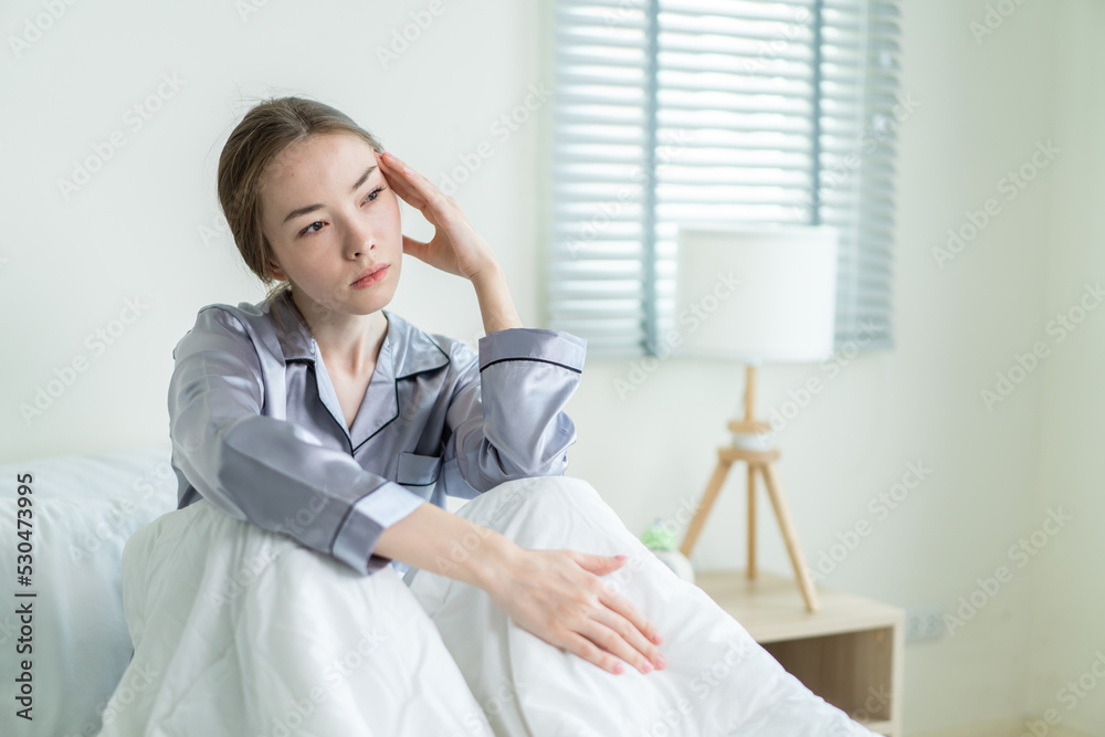 Caucasian young girl in pajamas feel sick while sit on bed in bedroom. Caucasian young girl in pajamas feel sick while sit on bed in bedroom.