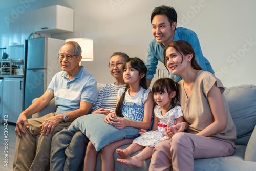 Asian happy family watching funny movie on television together at home