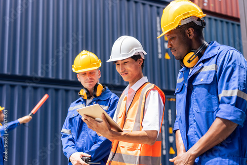 Group of attractive worker male people working in container terminal.