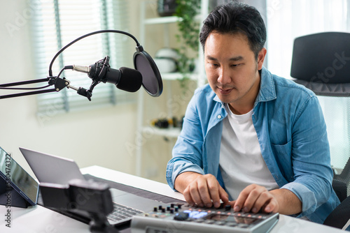 Asian attractive audio DJ man speaks into microphone to broadcasting.