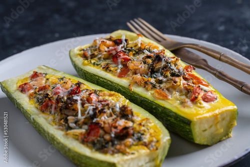 Zucchini stuffed with shrimps, vegetables and cheese. Baked zucchini boats photo