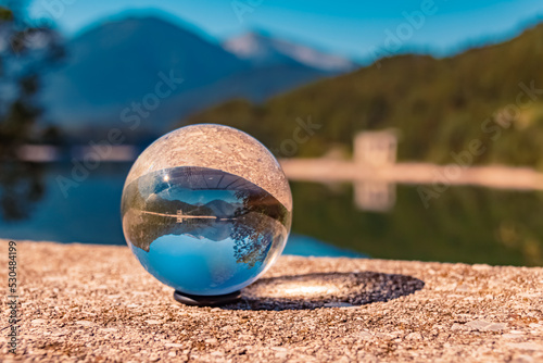 Crystal ball alpine landscape shot at the famous Sylvenstein lake, Lenggries, Bavaria, Germany