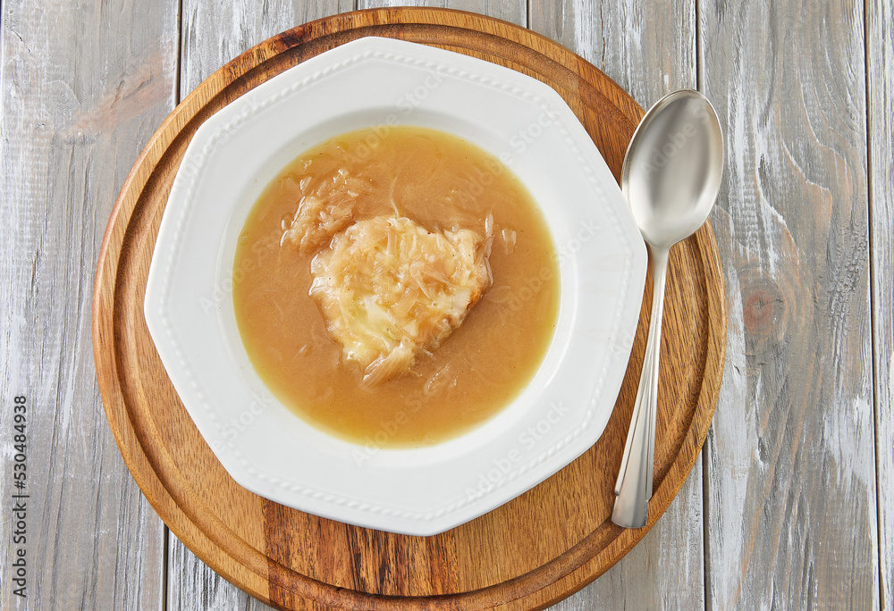 French recipe onion soup in bowl with spoon. French gourmet food French recipe onion soup in bowl with spoon. French gourmet food