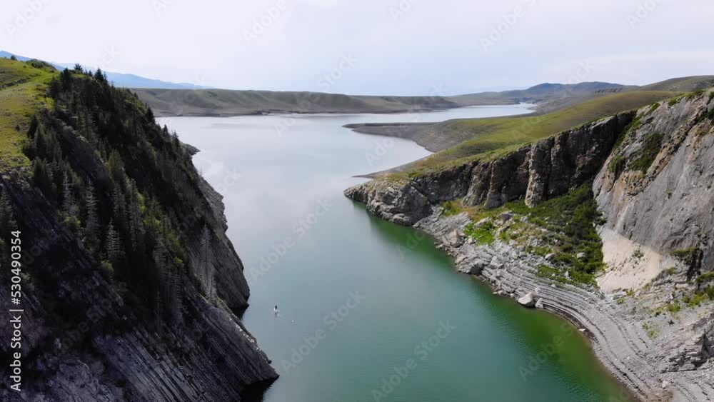 A team of tourists rowing on a SUP board along the river among the rocks. Water sports. A team of tourists rowing on a SUP board along the river among the rocks. Water sports.