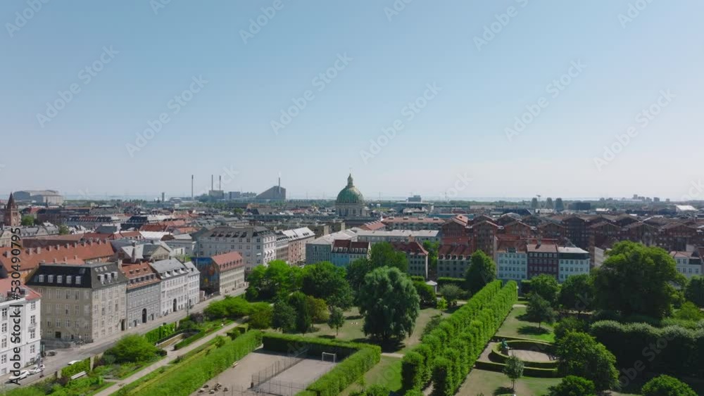 Fly above park in city. Panoramic view of town development, apartment houses and large church tower. Copenhagen, Denmark Fly above park in city. Panoramic view of town development, apartment houses and large church tower. Copenhagen, Denmark