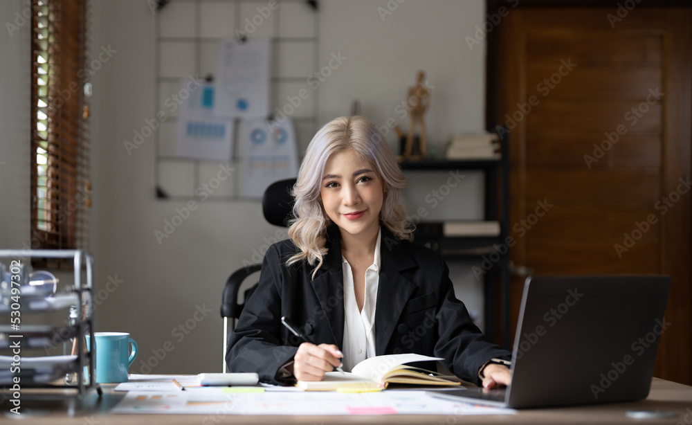 Portrait charming asian businesswoman sitting working on laptop computer at home office Portrait charming asian businesswoman sitting working on laptop computer at home office