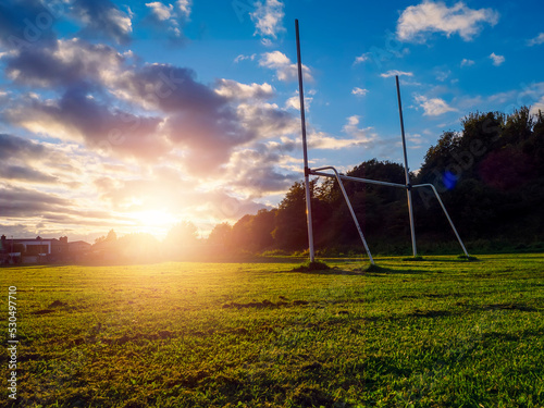 Foto Small tall goal post on training field for rugby and Irish national games hurling, camogie, Gaelic football and soccer at sunset