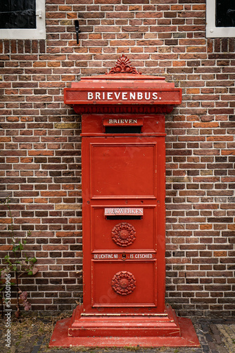 Fotografie, Obraz traditional old Dutch red postbox mounted in a cotswold stone wall
