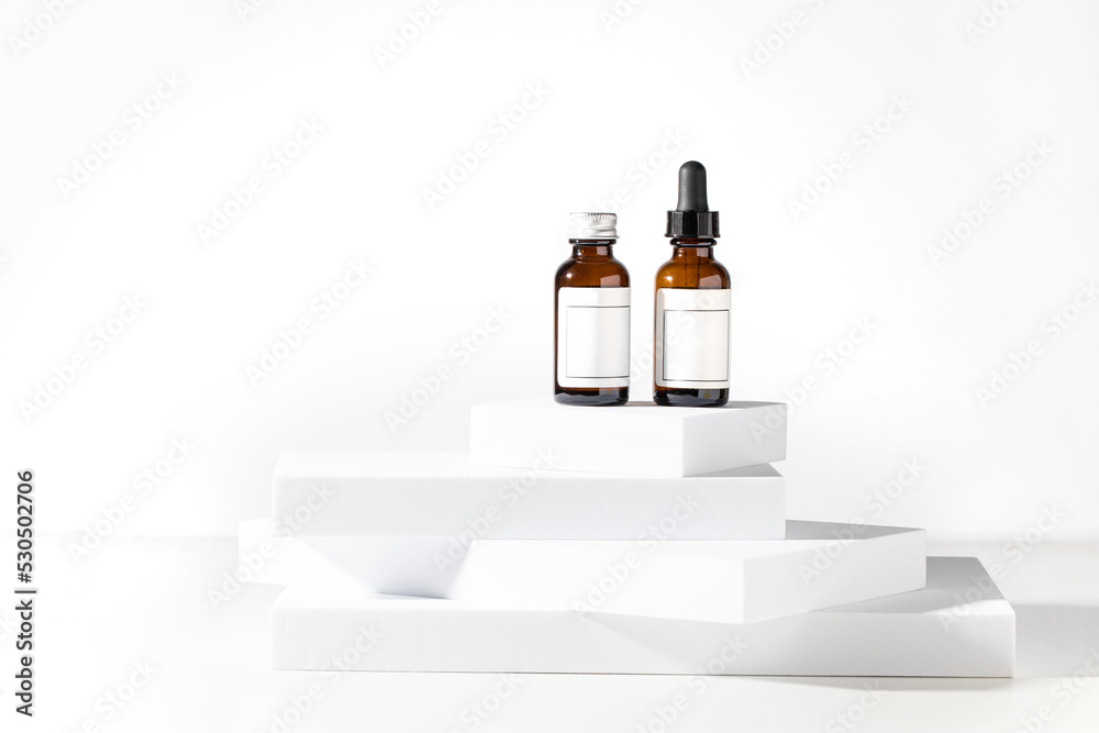 Two phase copper peptides dropper bottles for reduce fine lines, wrinkles, and sagging skin on the podiums at white background. Two phase copper peptides dropper bottles for reduce fine lines, wrinkles, and sagging skin on the podiums at white background.
