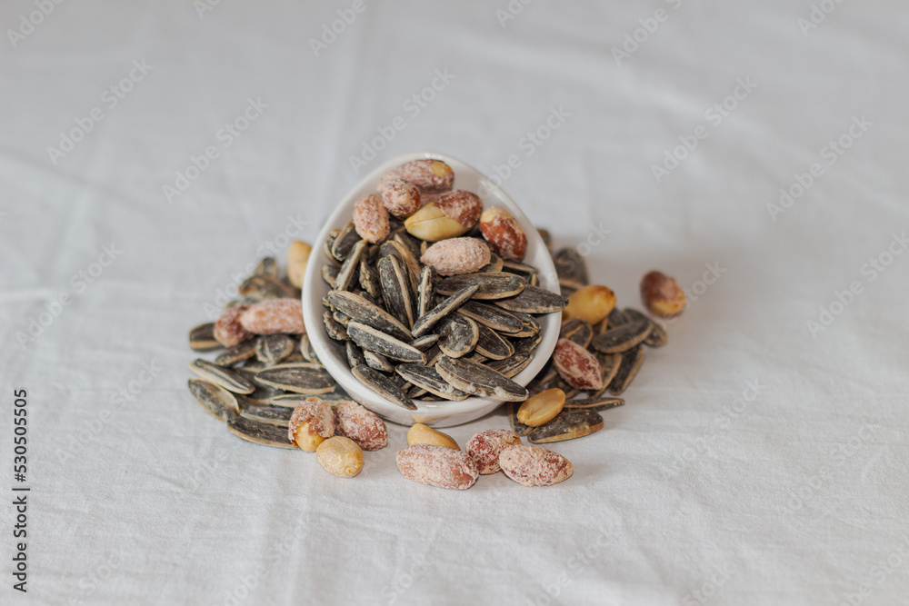 Roasted salted peanuts and roasted salted sunflower seeds. Close-up. Nuts. Eaten.