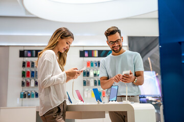 Happy young people shopping new mobile phone in a store. People technology device new concept