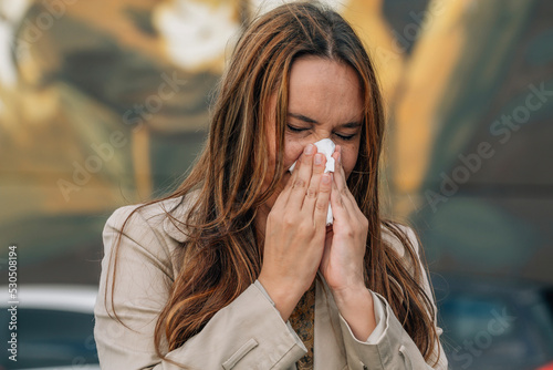 woman with allergy or an infection sneezing