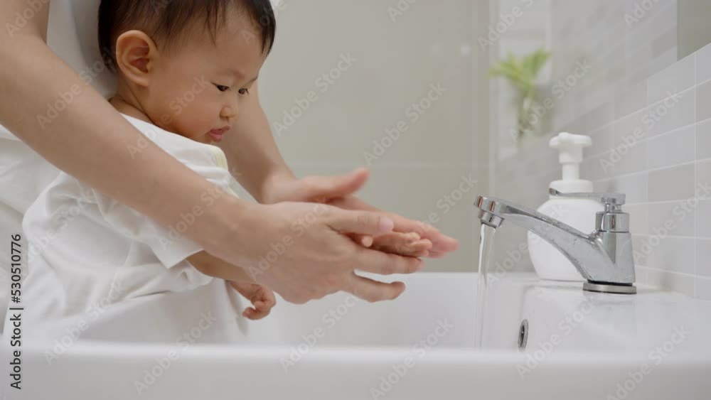 Mother practice Toddler washing his hands after handling an object to prevent infection with the virus. Washing your hands frequently dispose virus.concept for prevent germs and virus Mother practice Toddler washing his hands after handling an object to prevent infection with the virus. Washing your hands frequently dispose virus.concept for prevent germs and virus