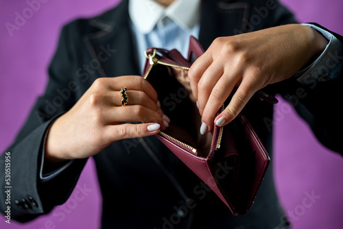 Unhappy young bankrupt woman with empty wallet or showing her empty wallet.