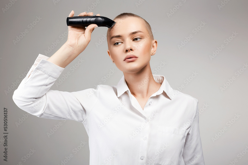 pretty young woman cutting her hair. bald Girl with hairclipper pretty young woman cutting her hair. bald Girl with hairclipper