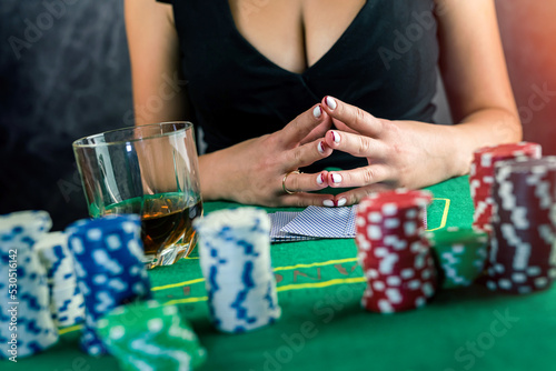 Young woman taking money from her wallet betting everything in a risky game of poker.